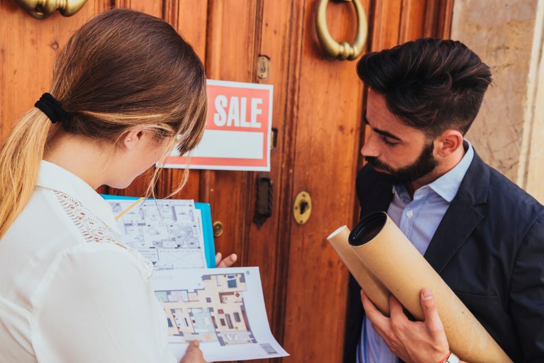 ActivePropertyCare Brendan discussing property plans with a landlord near a house sale sign.