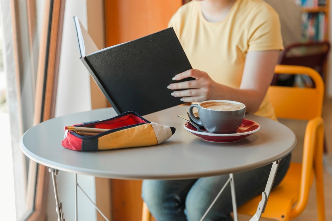 Person reading Must Reads ActivePropertyCare property care guides beside a laptop and coffee.