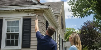 Deferred Maintenance and Property Value: Warning Signs, Costs, and Repair Priorities Home inspector and homeowner reviewing deferred maintenance and property value risks on a house exterior.