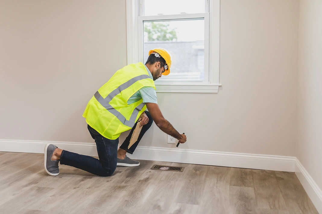 Inspector completing final checks inside a renovated residential room