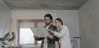 Home Renovation Budget: Estimate Costs, Set Contingency, and Control Changes Homeowners reviewing a home renovation budget and floor plan inside a remodeling project.