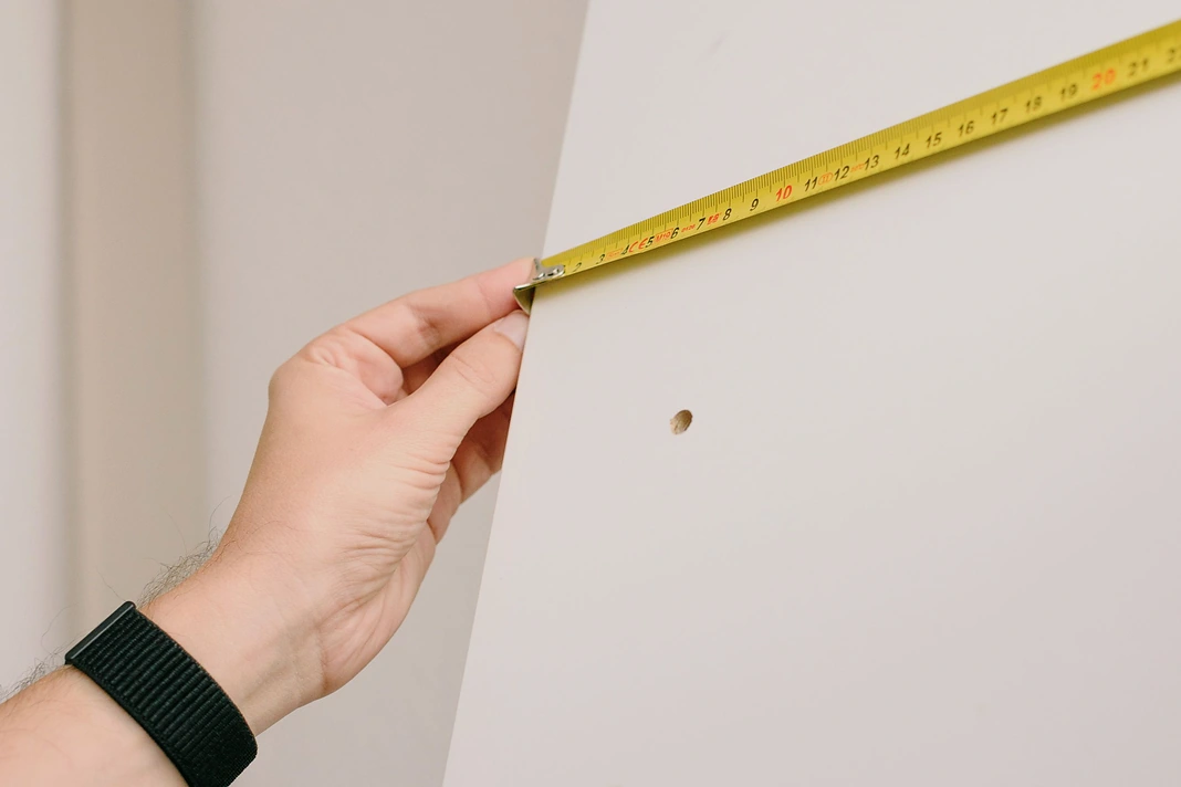 Hand measuring a wall before home renovation work