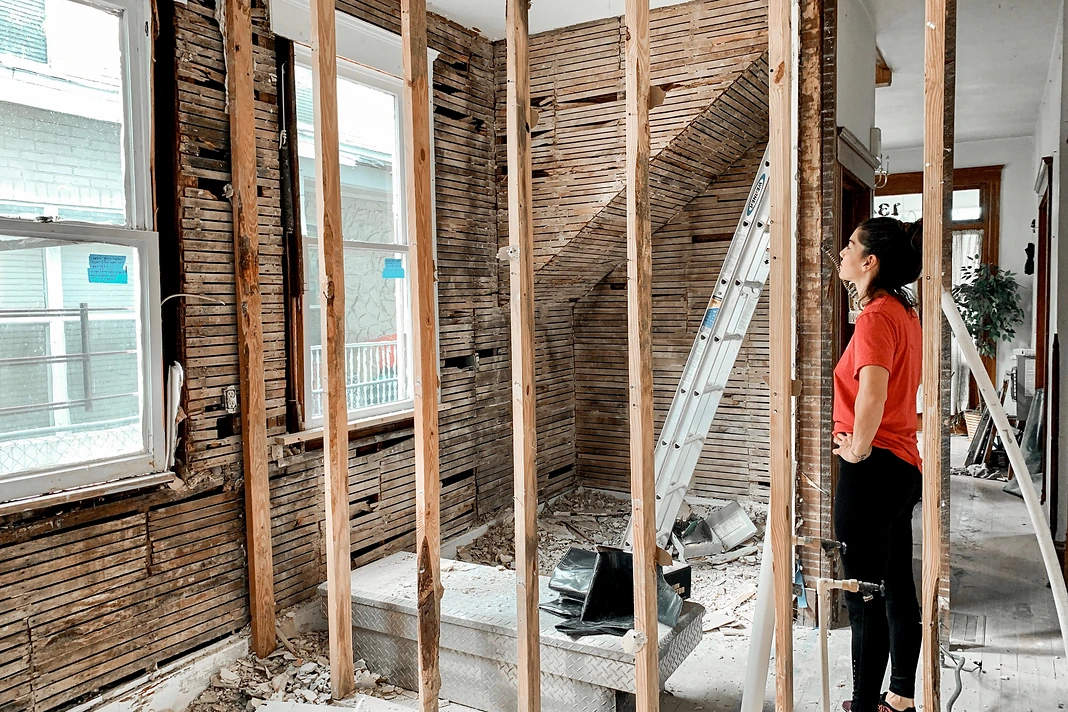 Homeowner reviewing exposed wall framing during a residential renovation project