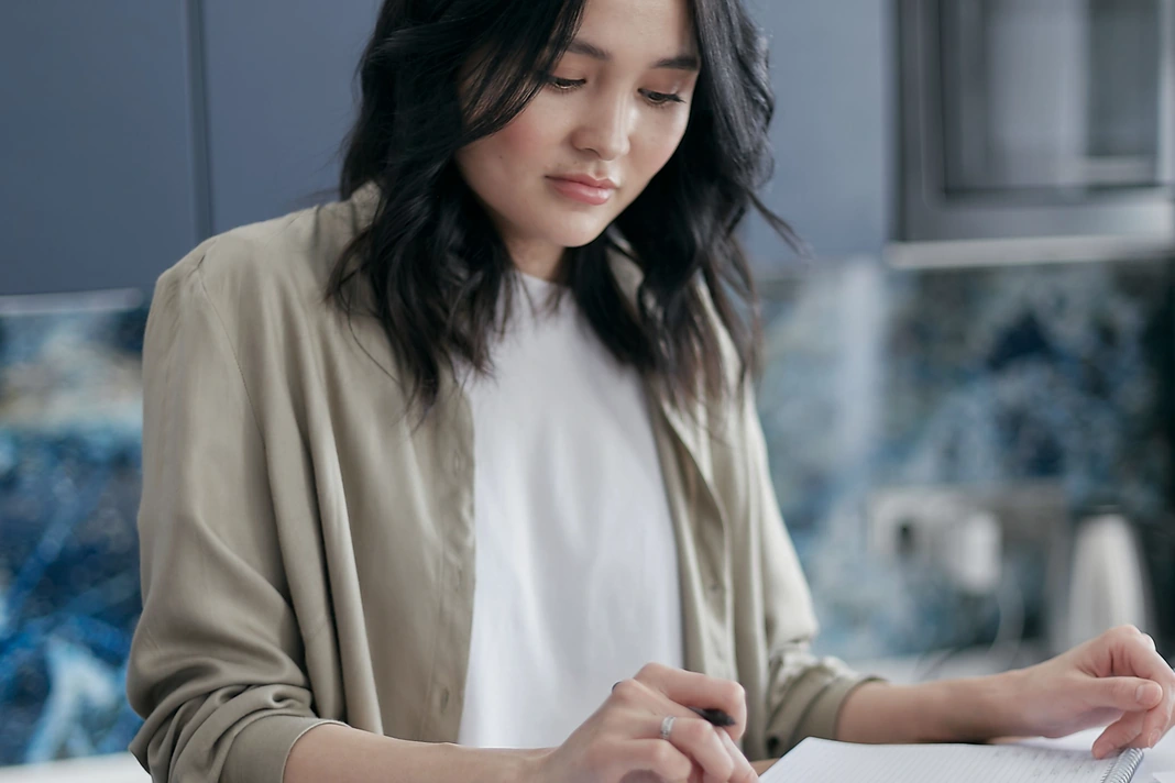 Homeowner calculating a home renovation budget with bills and a calculator