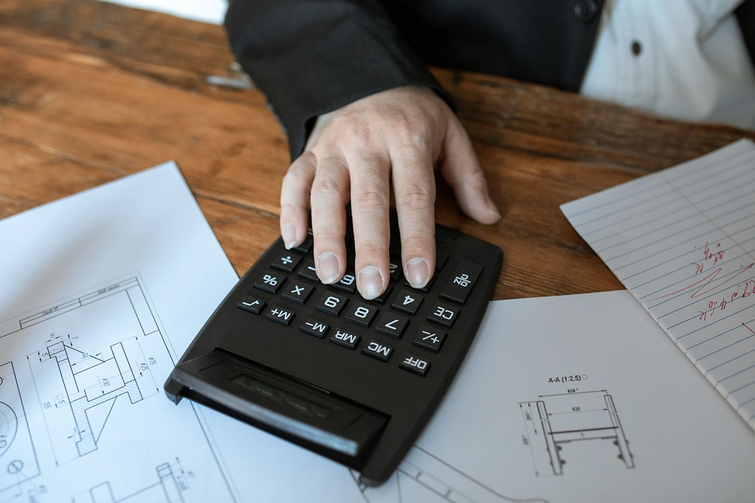Calculator on construction drawings during home renovation budget planning