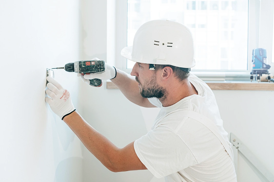 Qualified repair worker installing an electrical fitting inside a rental home