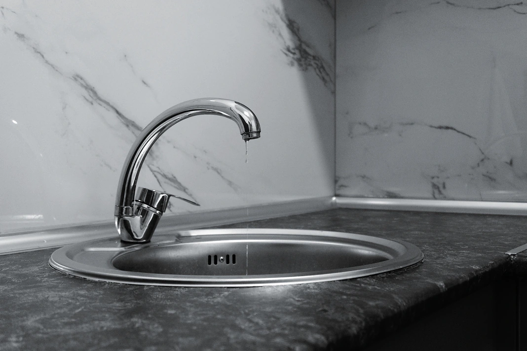 Dripping kitchen faucet showing a plumbing repair issue in a rental property